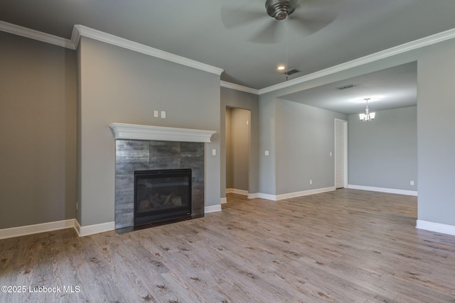 136 Preston Hollow Ln, Wolfforth, TX 79382 - unfurnished living room with wood finished floors, ornamental molding, ceiling fan, a fireplace, and a chandelier