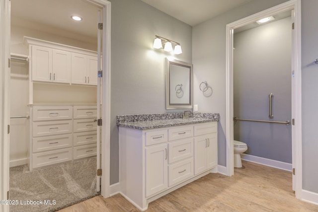 136 Preston Hollow Ln, Wolfforth, TX 79382 - bathroom featuring vanity, wood finished floors, a spacious closet, and recessed lighting
