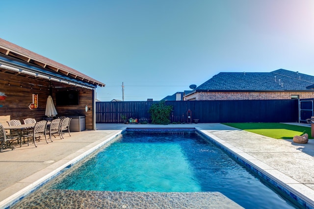 view of pool with exterior bar and a patio