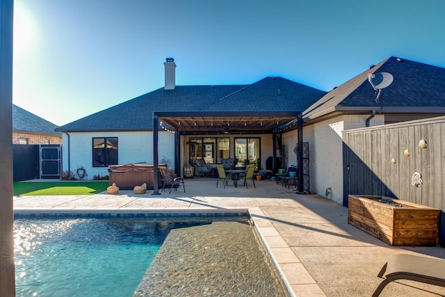 rear view of house with a pool with hot tub and a patio area