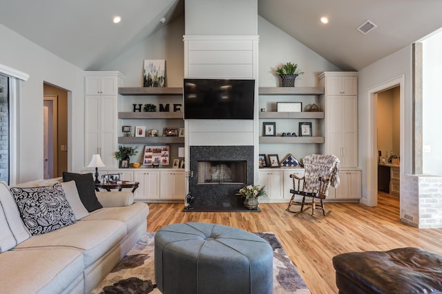 living room featuring high vaulted ceiling and light hardwood / wood-style floors