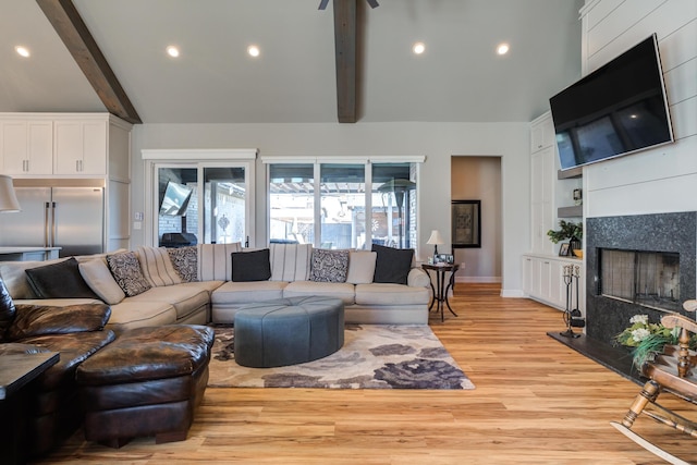 living room featuring vaulted ceiling with beams and light wood-type flooring