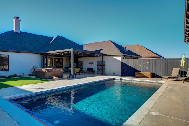 view of swimming pool featuring a hot tub and a patio area