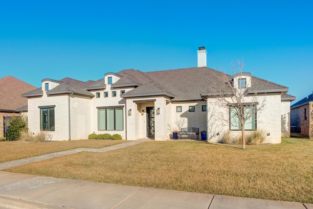 french provincial home with a front yard