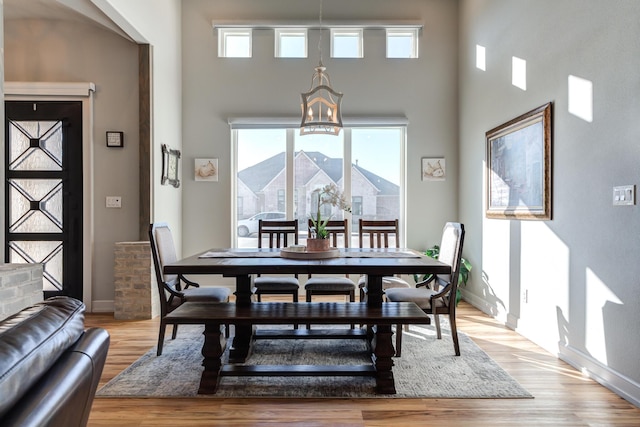 dining area with an inviting chandelier and light hardwood / wood-style flooring