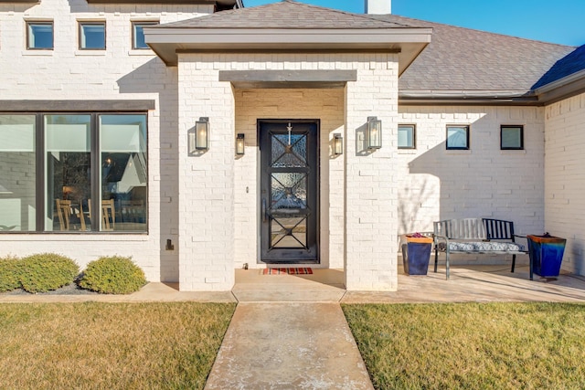 view of exterior entry featuring a yard