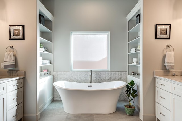 bathroom featuring vanity, a bath, and tile walls