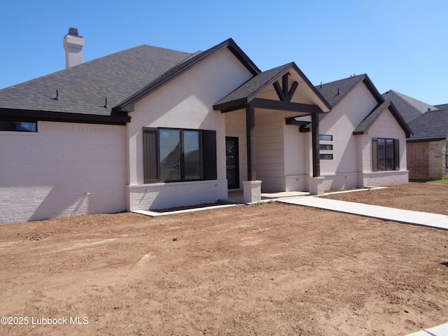 4622 140th St, Lubbock, TX 79423 - view of front facade featuring brick siding, a chimney, and roof with shingles