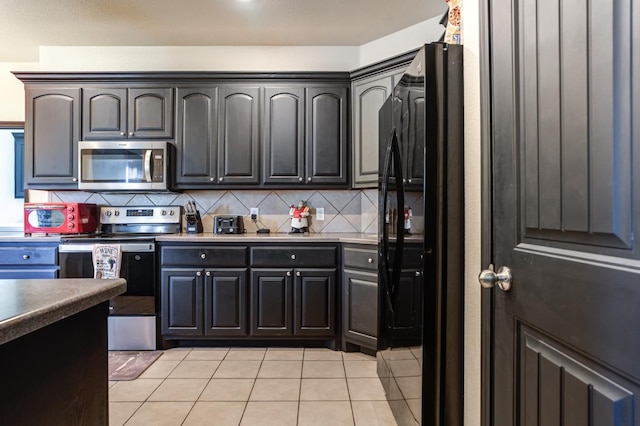 kitchen with light tile patterned floors, backsplash, and appliances with stainless steel finishes