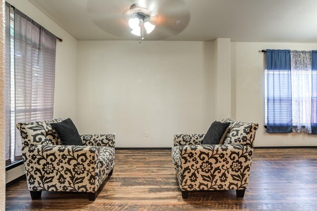 sitting room with ceiling fan and dark hardwood / wood-style flooring