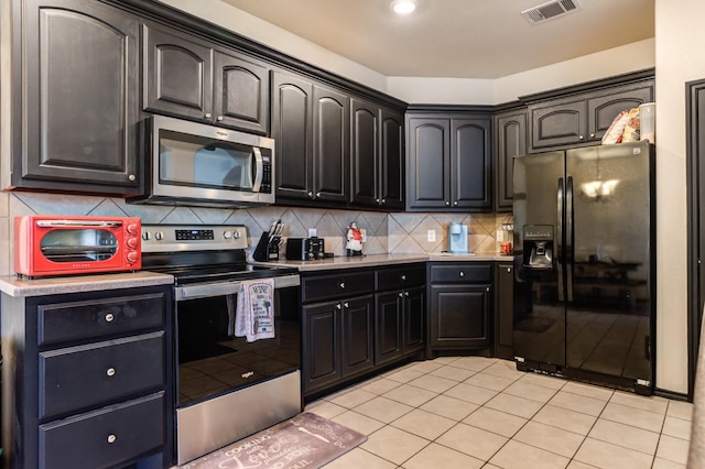 kitchen with tasteful backsplash, stainless steel appliances, and light tile patterned flooring