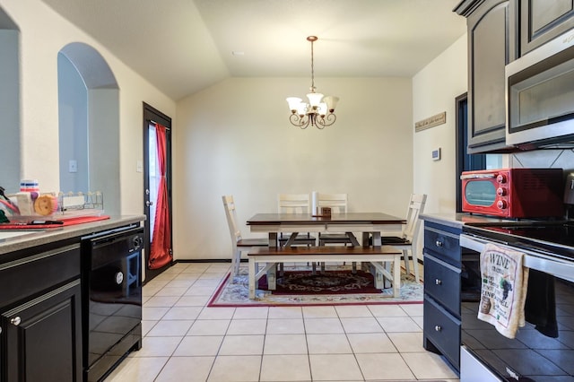 kitchen featuring an inviting chandelier, decorative light fixtures, vaulted ceiling, light tile patterned floors, and appliances with stainless steel finishes