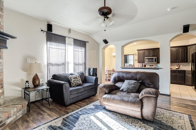 living room with lofted ceiling, dark wood-type flooring, and ceiling fan