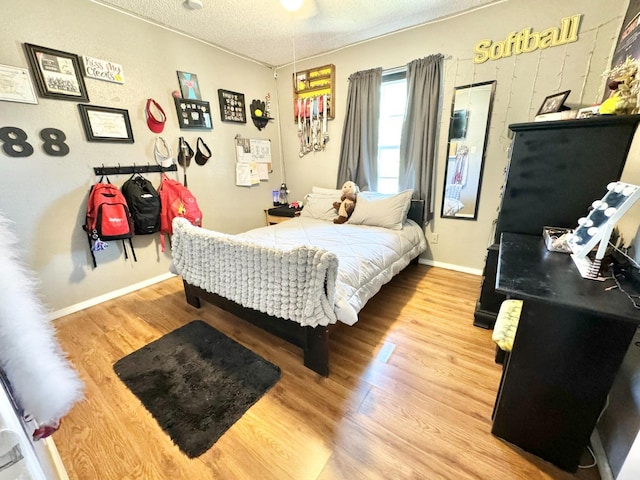 bedroom featuring hardwood / wood-style flooring and a textured ceiling