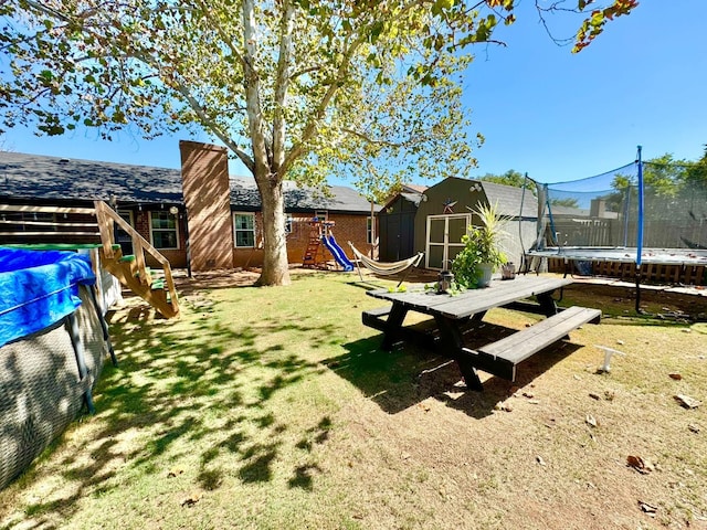 view of yard with a storage unit, a playground, and a trampoline