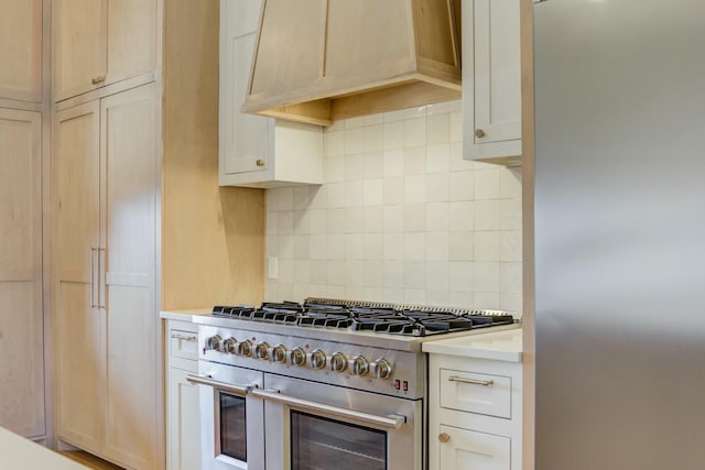 kitchen featuring stainless steel appliances, light countertops, backsplash, and custom exhaust hood