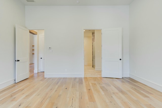 spare room with light wood-style flooring and baseboards