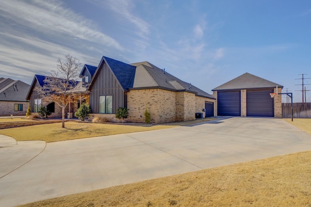 view of front facade with board and batten siding, a front yard, concrete driveway, and fence