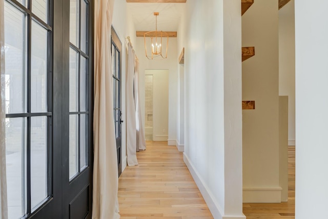 hall featuring a chandelier, plenty of natural light, and light wood finished floors