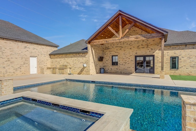 outdoor pool with french doors, a patio, and an in ground hot tub