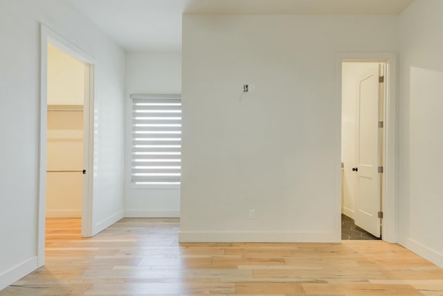 empty room featuring baseboards and light wood finished floors