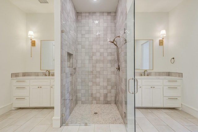 bathroom featuring a stall shower, two vanities, visible vents, and tile patterned floors