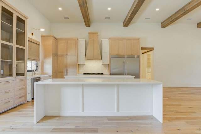 kitchen with stainless steel appliances, light countertops, a large island, and custom exhaust hood