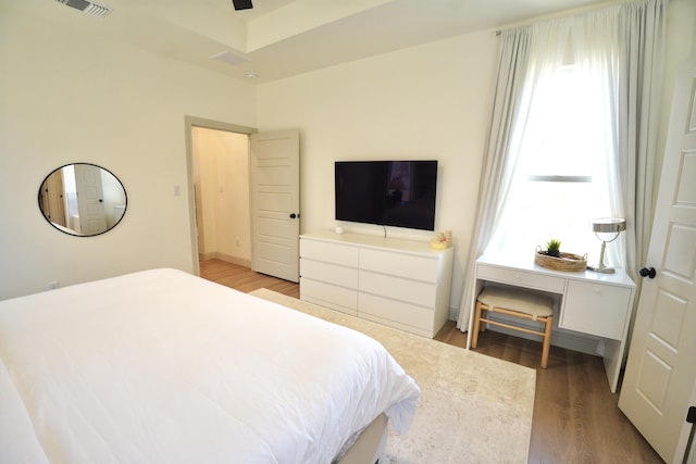 bedroom with light wood-style floors and visible vents