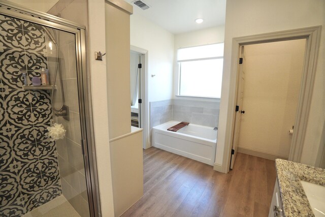 bathroom with wood finished floors, visible vents, and a stall shower
