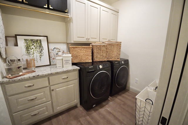 clothes washing area with baseboards, cabinet space, dark wood-style flooring, and washing machine and dryer