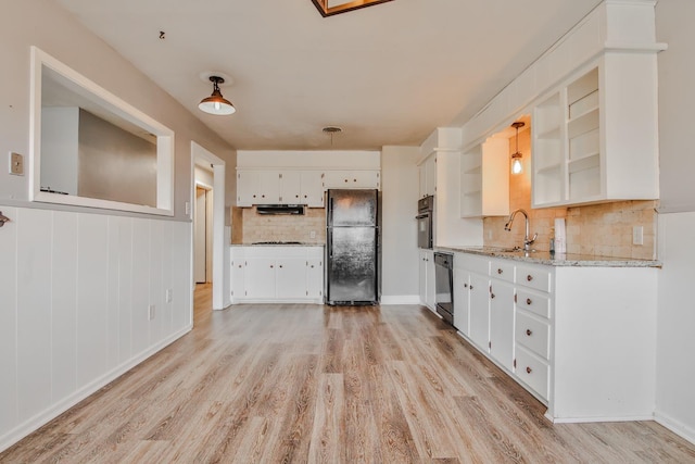 kitchen with sink, white cabinets, hanging light fixtures, light hardwood / wood-style floors, and black appliances