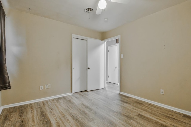 unfurnished bedroom featuring a closet, ceiling fan, and light wood-type flooring