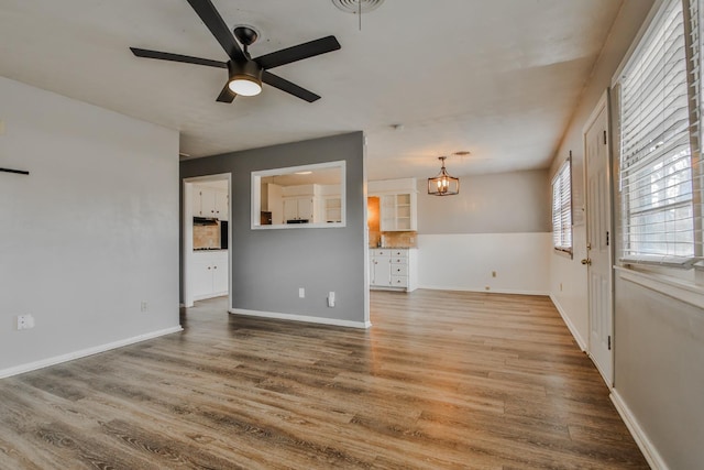 unfurnished living room featuring wood-type flooring and ceiling fan