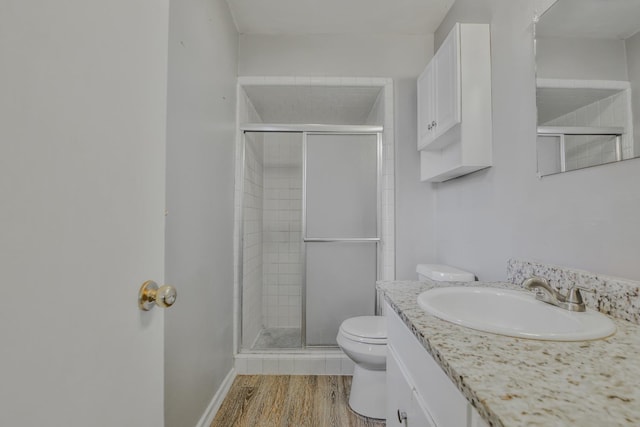 bathroom featuring hardwood / wood-style flooring, vanity, toilet, and walk in shower