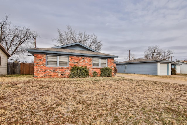 view of front of home with a garage, an outdoor structure, and a front lawn