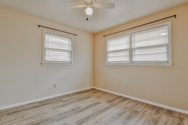 empty room with ceiling fan, a healthy amount of sunlight, and light hardwood / wood-style floors