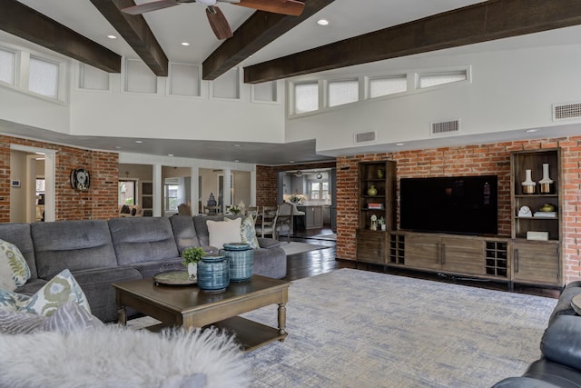 living area featuring visible vents, ceiling fan, and a high ceiling