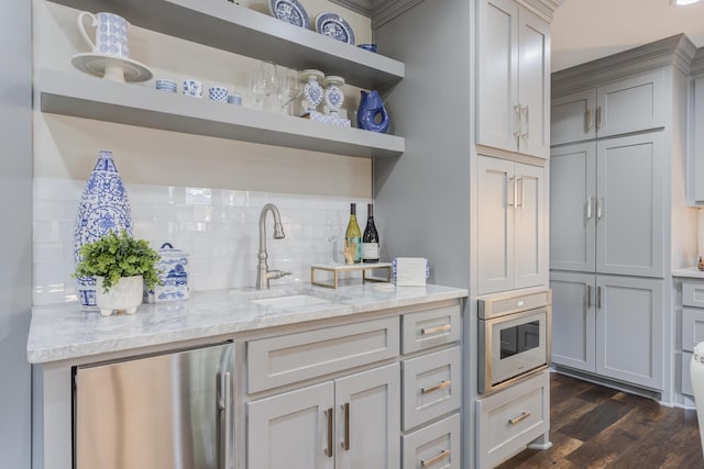 kitchen with light stone countertops, open shelves, dark wood-type flooring, backsplash, and freestanding refrigerator