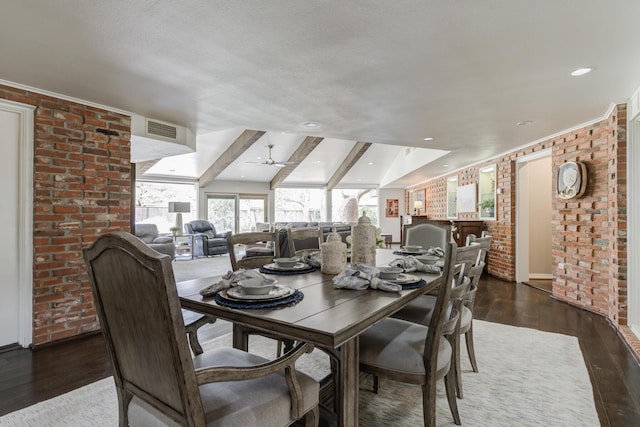 dining room featuring beamed ceiling, brick wall, a ceiling fan, visible vents, and wood finished floors