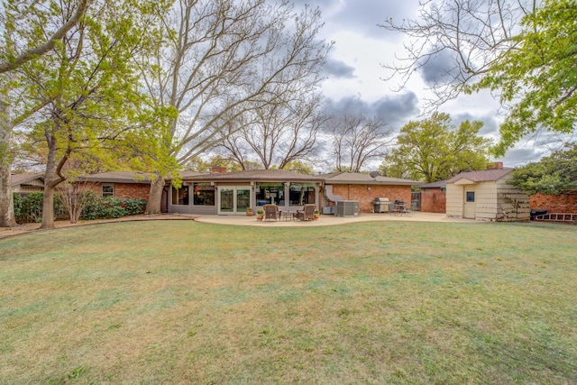 back of house featuring a patio, an outdoor structure, cooling unit, and a lawn