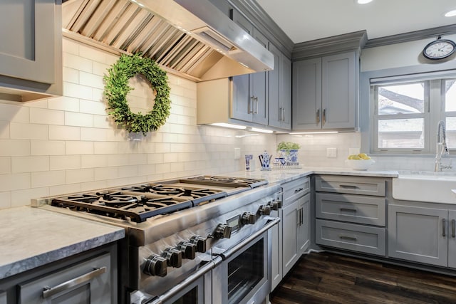 kitchen with range with two ovens, gray cabinets, custom range hood, and a sink