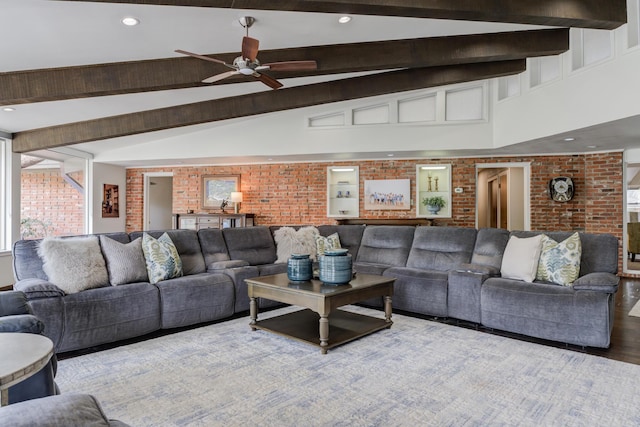 living area featuring beamed ceiling, recessed lighting, brick wall, a ceiling fan, and wood finished floors