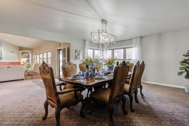 dining room with an inviting chandelier, carpet, a wealth of natural light, and vaulted ceiling