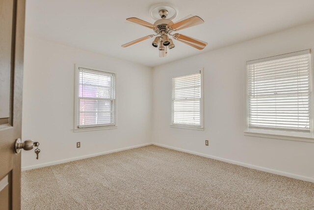 carpeted spare room with ceiling fan