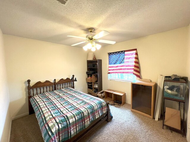 carpeted bedroom with ceiling fan and a textured ceiling