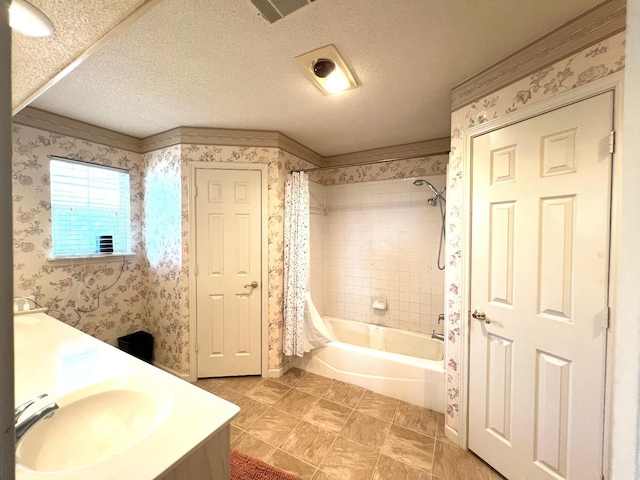 bathroom with shower / bath combo with shower curtain, vanity, and a textured ceiling