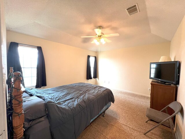 carpeted bedroom featuring ceiling fan and a textured ceiling