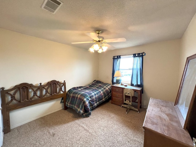 carpeted bedroom with ceiling fan and a textured ceiling