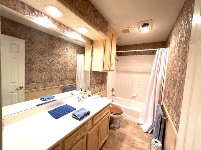 full bathroom with vanity, shower / bath combination with curtain, a textured ceiling, and toilet