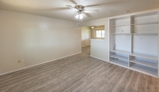 spare room featuring ceiling fan, wood-type flooring, and a textured ceiling